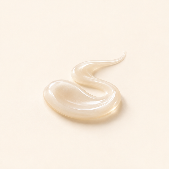 Glossy cream liquid swirl representing conditioning agents.